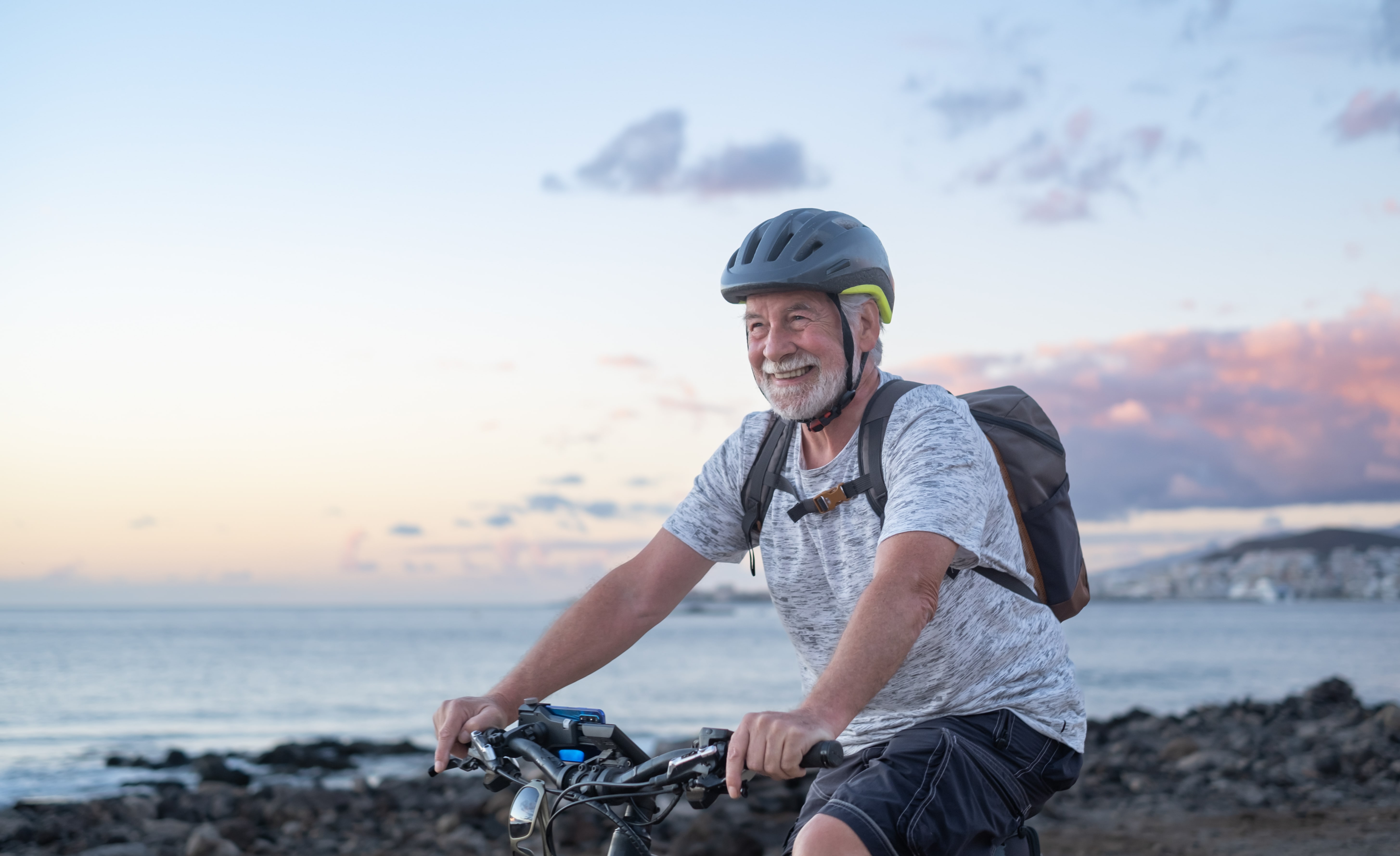 happy-senior-cyclist-man-at-the-beach-at-sunset 